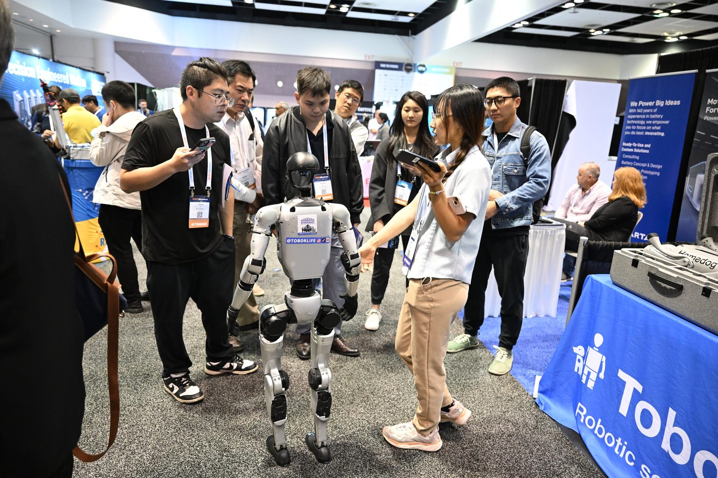 Attendees interacting with a humanoid robot at an exhibitor booth